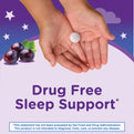 Child's hands hold a speckled white chewable tablet with purple grapes against a starry night background.